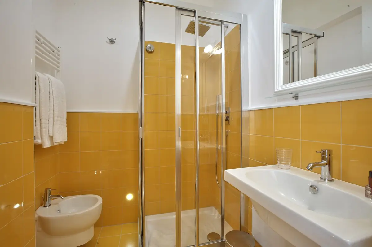 Il bagno della Camera Gialla: maiolica ocra, doccia, bidet e scaldasalviette