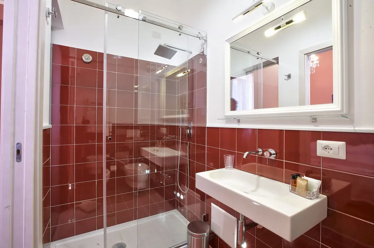 Il bagno della Camera Rossa: maiolica bordeaux e specchio a tutta parete