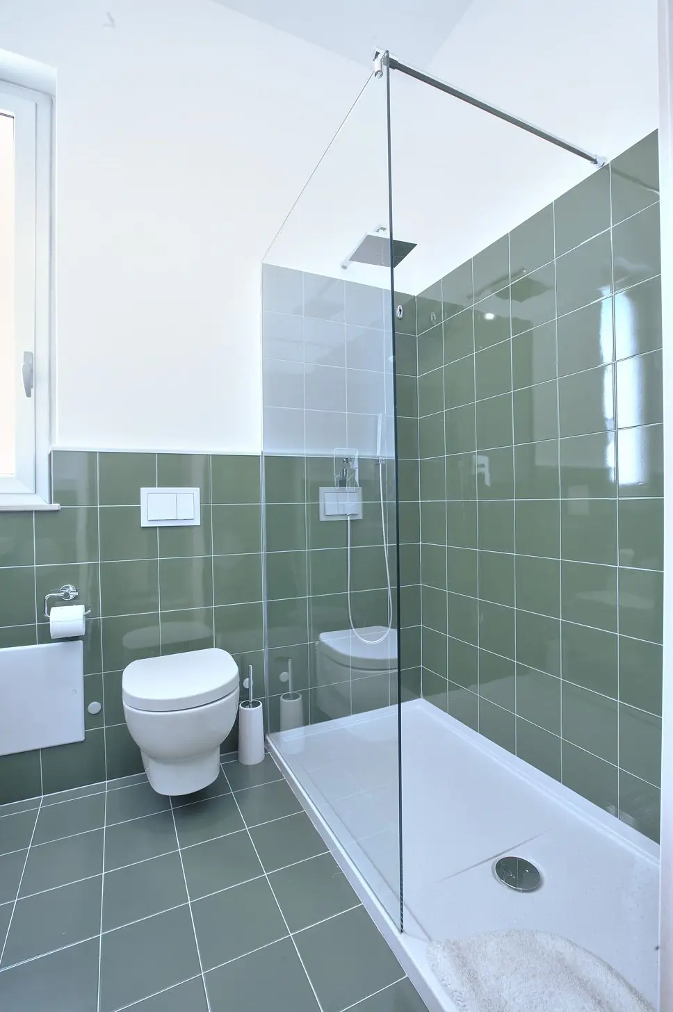 Il bagno della Camera Verde: maiolica salvia e doccia a pavimento con soffione a pioggia