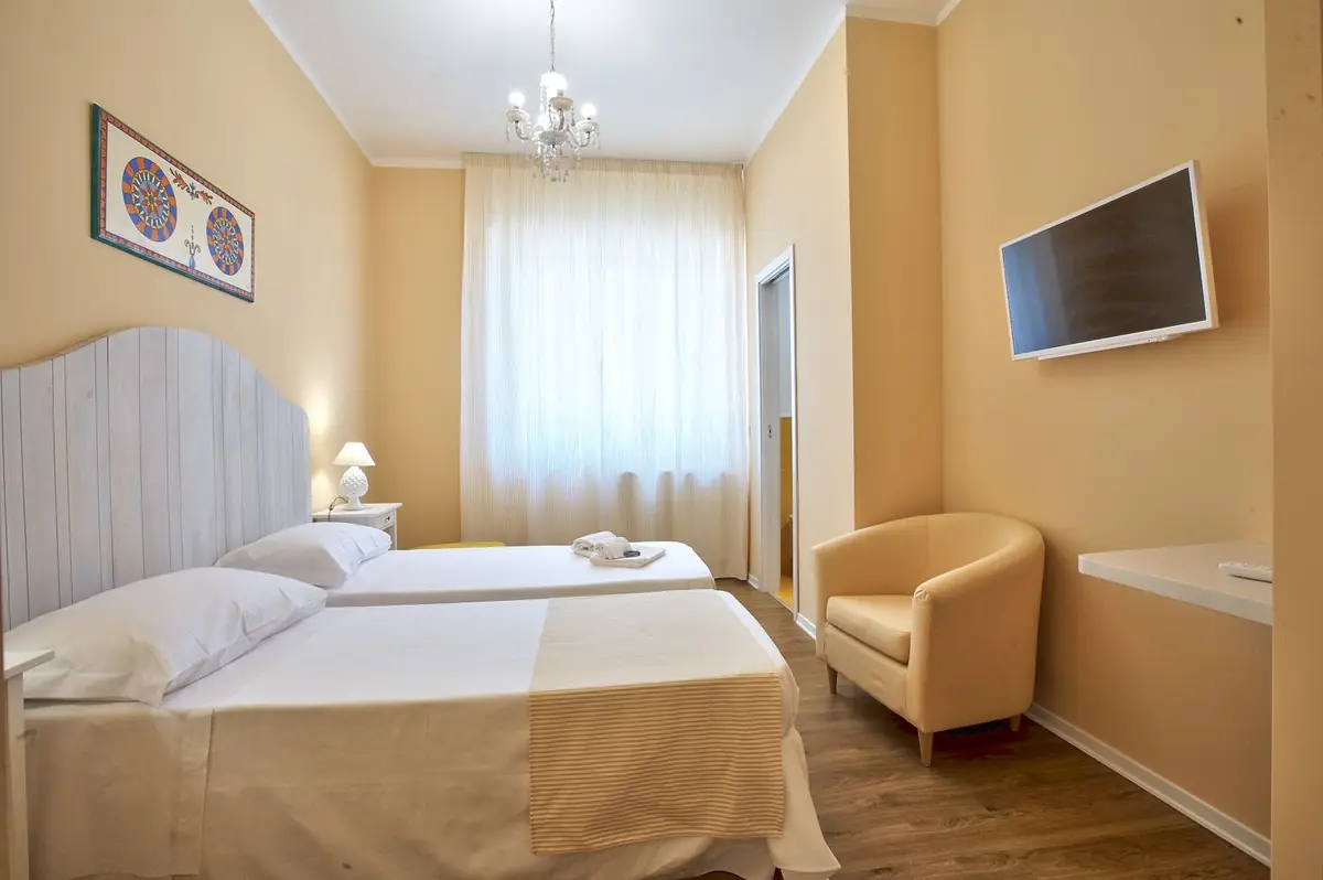 La Camera Gialla nella versione a due letti, con poltroncina e finestra sul corso