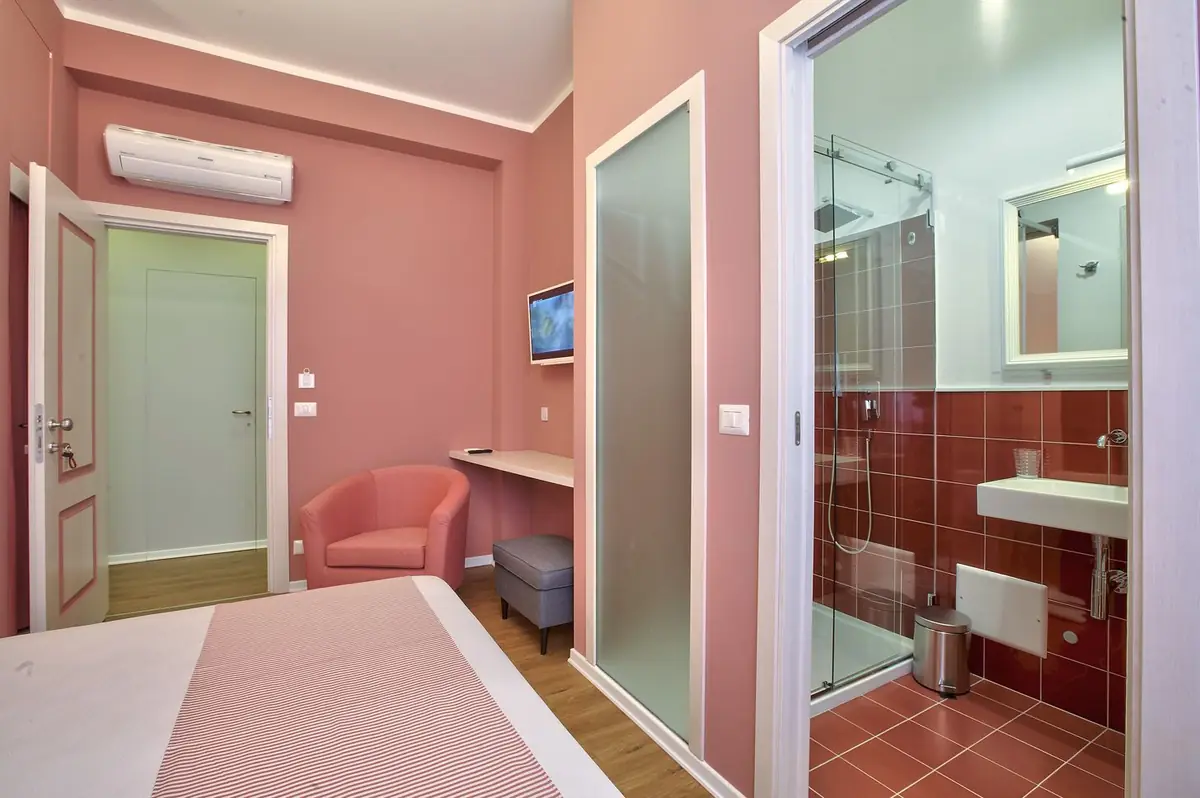 La Camera Rossa con la scrivania e la porta a vetri smerigliati del bagno