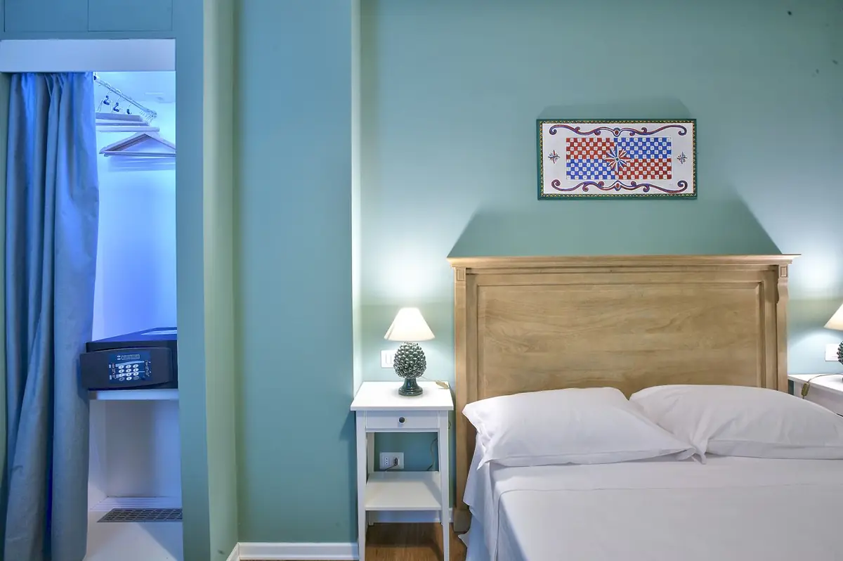 La Camera Verde: la testiera in legno e il pannello di ceramica sopra il letto
