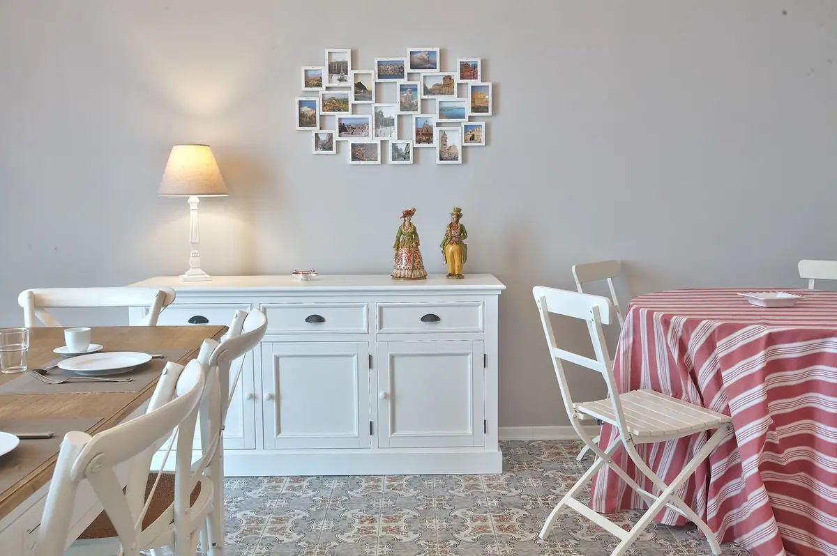 Il living dall'altro lato: la credenza, le cartoline alla parete e il tavolo apparecchiato