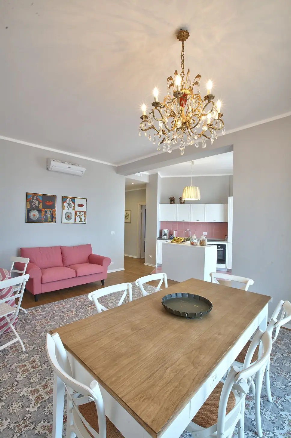 Il living in comune: il tavolo grande, il lampadario e le cementine originali
