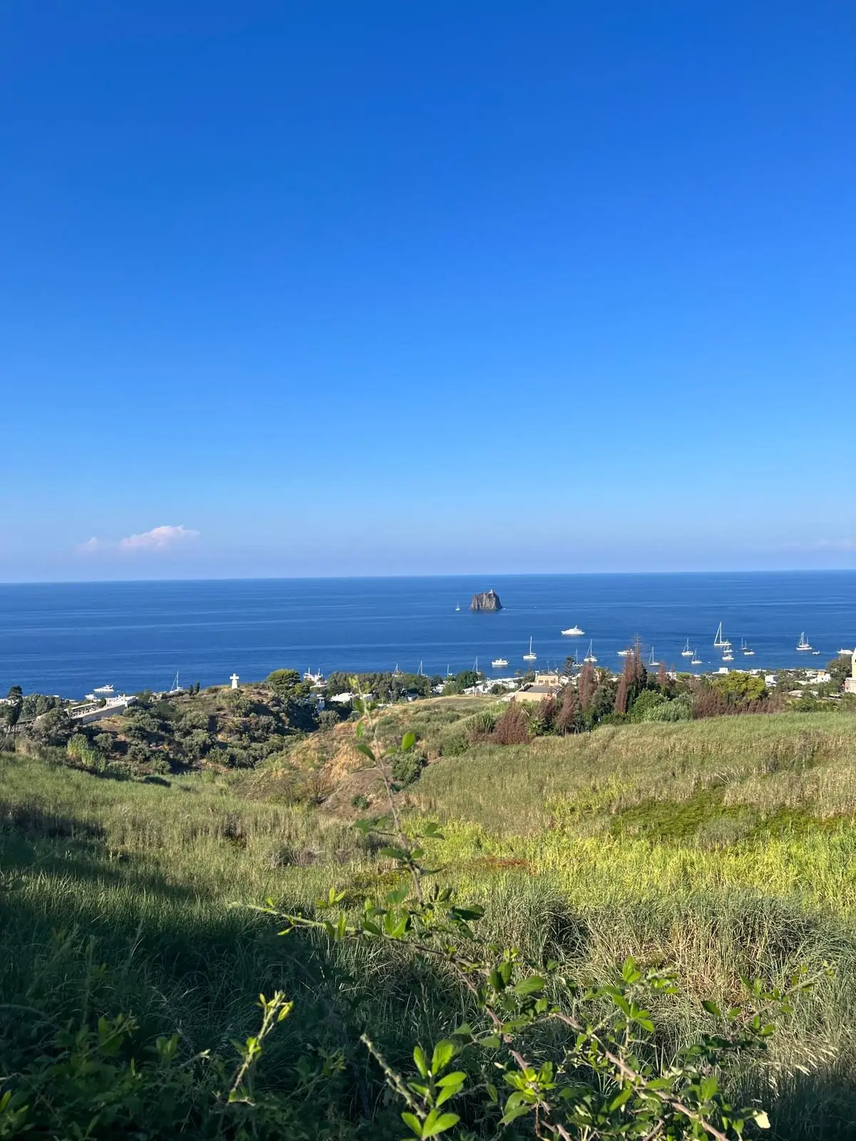 The village seen from the meadows above it, with Strombolicchio on the horizon