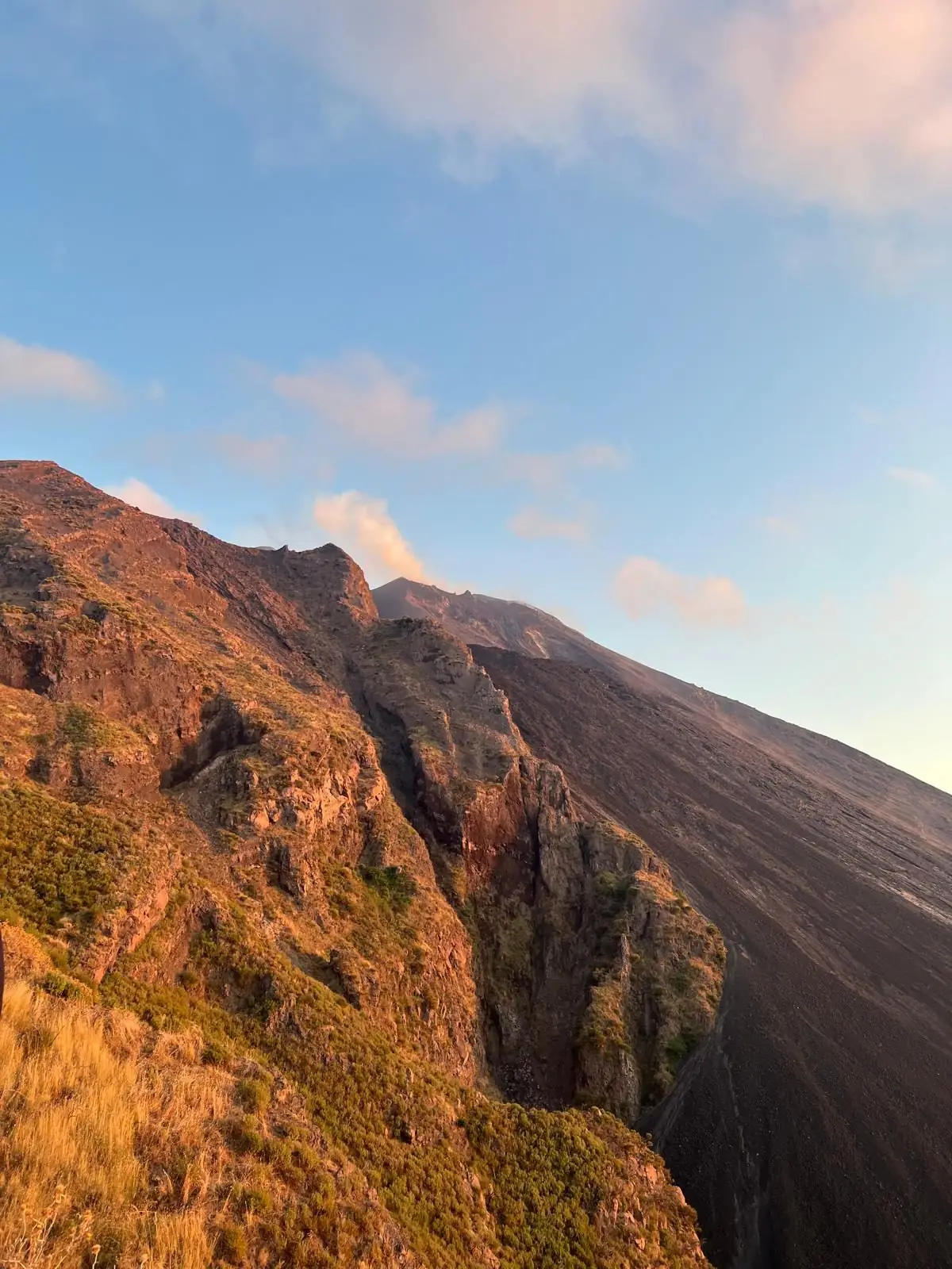 The volcano's ridge in warm evening light, with the black slope of the Sciara dropping away on the right