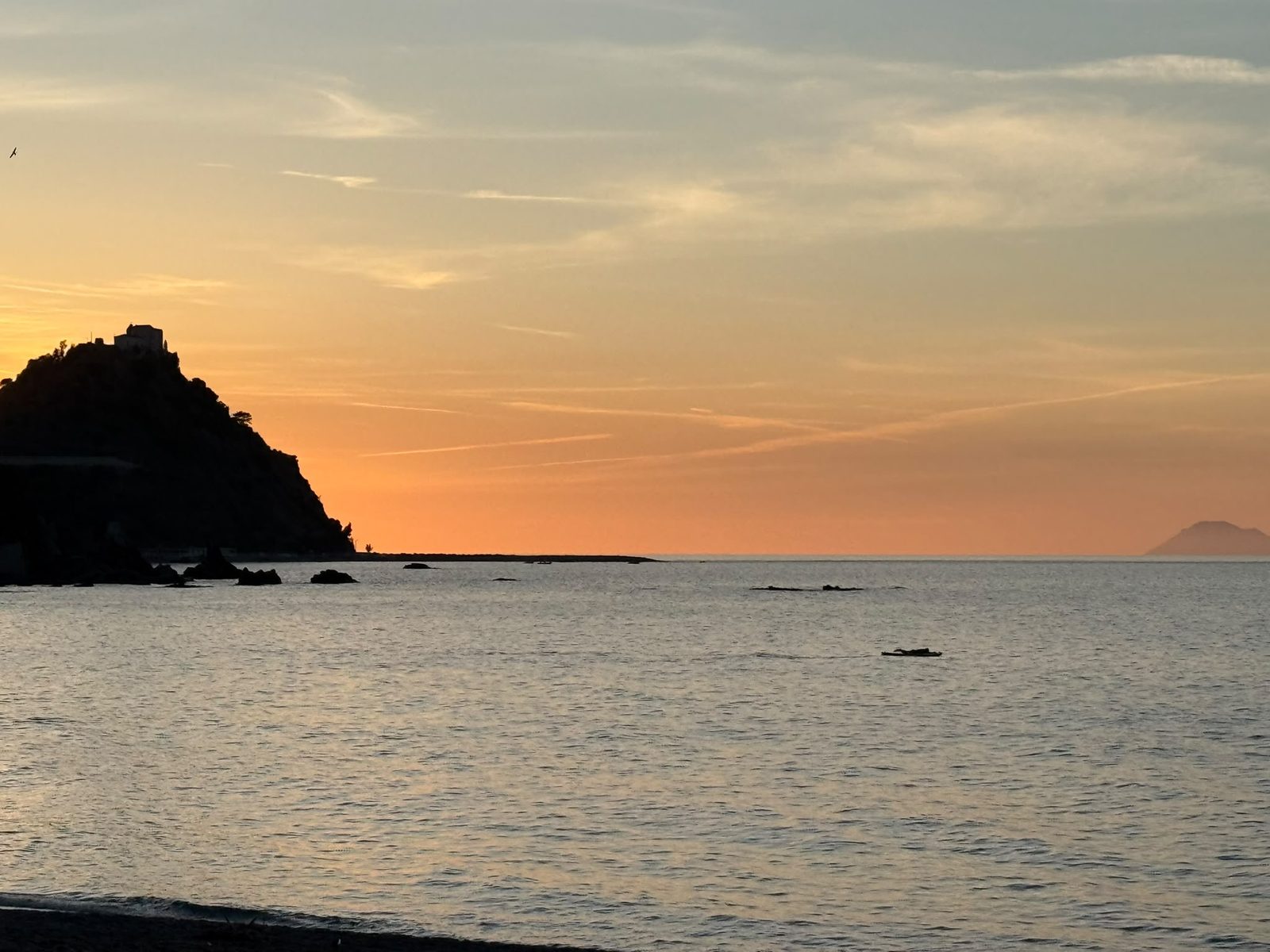 Il promontorio con il Santuario in controluce e un'isola all'orizzonte