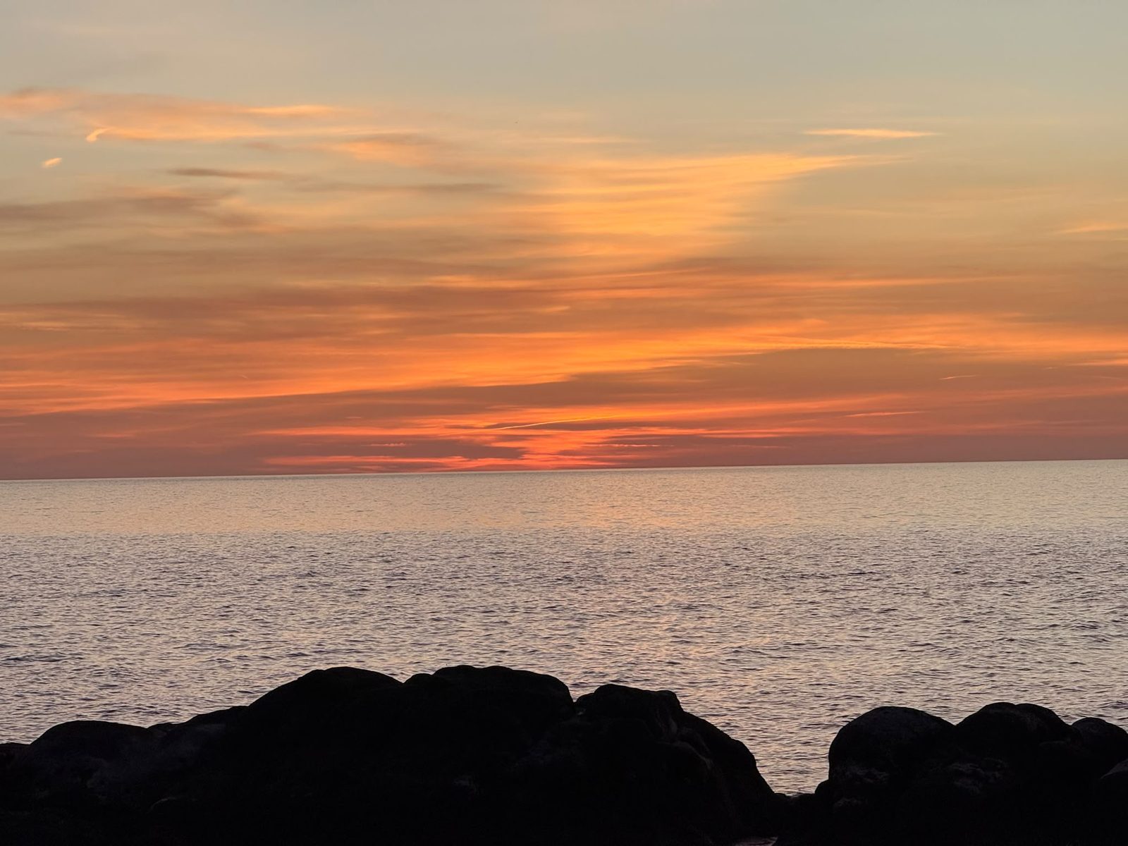 Gli scogli in silhouette e il cielo arancione sopra il Tirreno